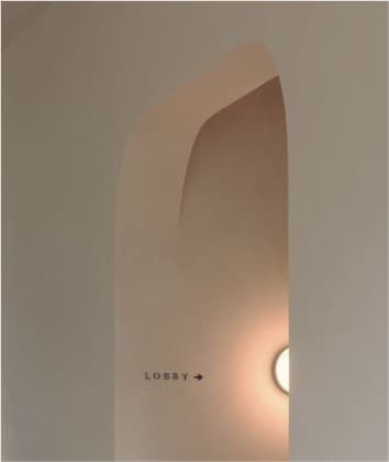 Curved architectural entry toward the lobby with soft light